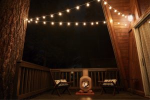 Fireplace and two wicker chairs on verandah of house